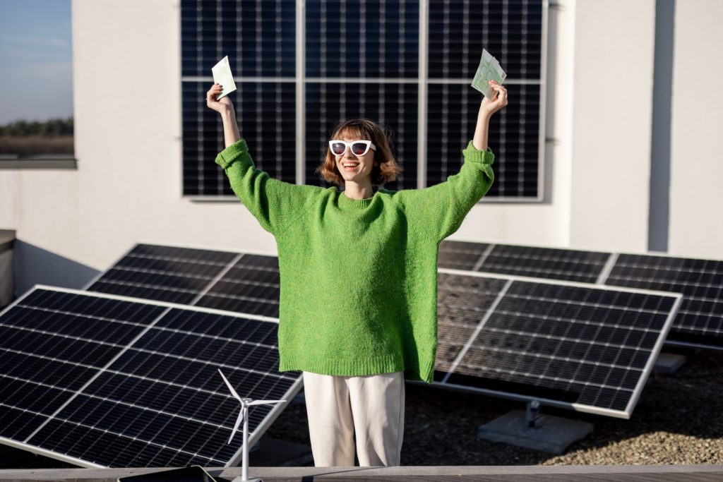 Happy household owner with money near solar power plant